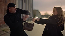 Мужчина вырывает сумку из рук женщины